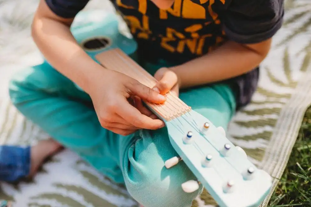Kindergitarre aus Holz, Gitarre für Kinder ab 3 Jahre, 53x17x6 cm, 6-saitige Spielzeuggitarre, Nylonsaiten - mit Waldtieren und Noten verziert - bemaltes Holz - Musikinstrumente für Kinder — 25
